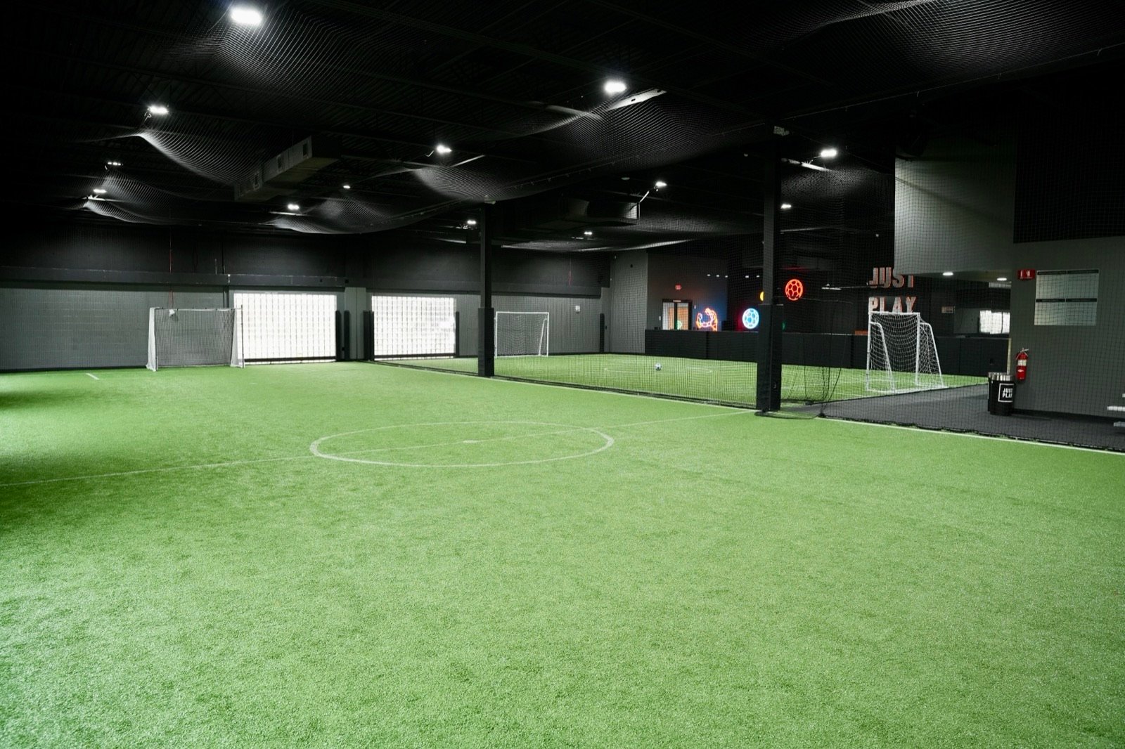 Wide view of the indoor fields at Just Play, divided by netting